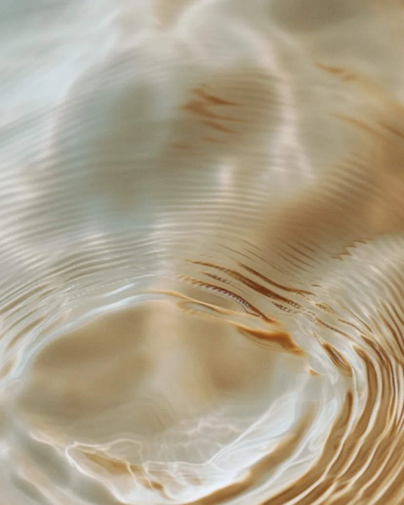 Konzentrische Ringe breiten sich auf ruhigem Wasser aus.
